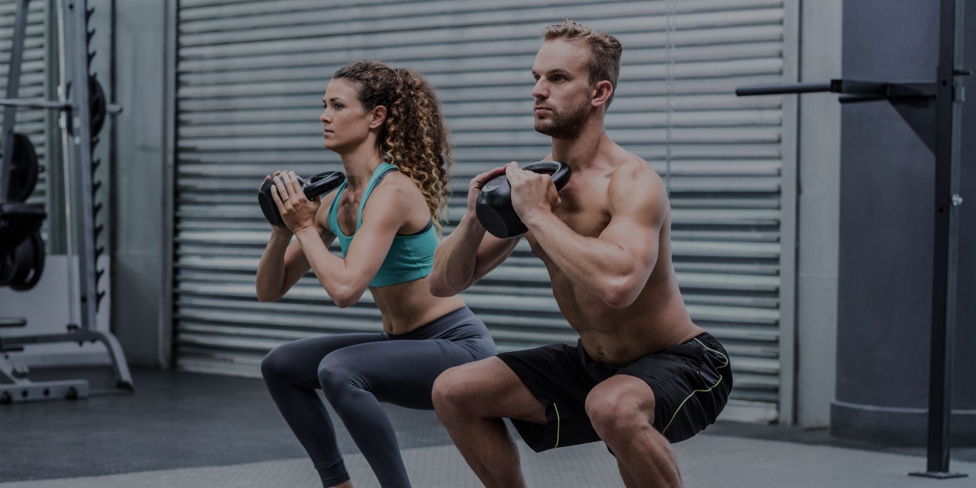 Two people exercising with dumbbells in a gym setting